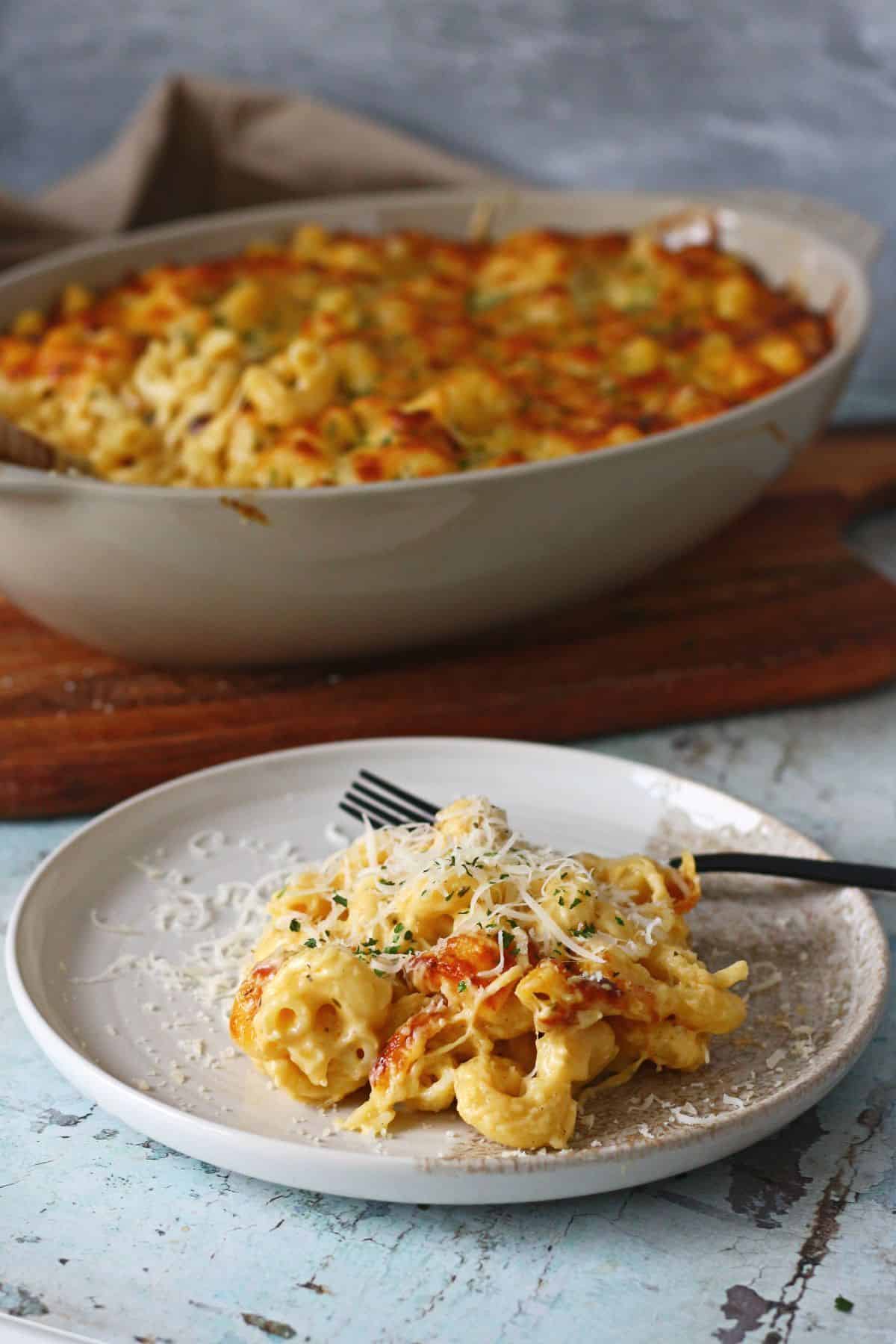 A serving of the Baked Four Cheese Mac & Cheese plated and topped with extra grated cheese, ready to eat.