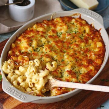 Creamy Baked Four Cheese Mac & Cheese served in a baking dish, showcasing the crispy, golden top and the rich, cheesy interior.