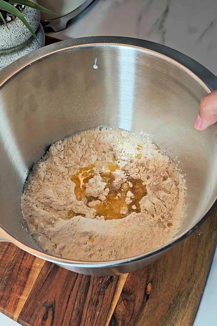 Mixing dough ingredients in a bowl for garlic rolls.