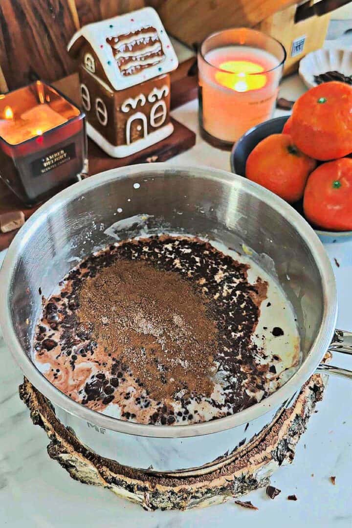 Chocolate, cocoa powder, and spices added to the infused milk in a saucepan.