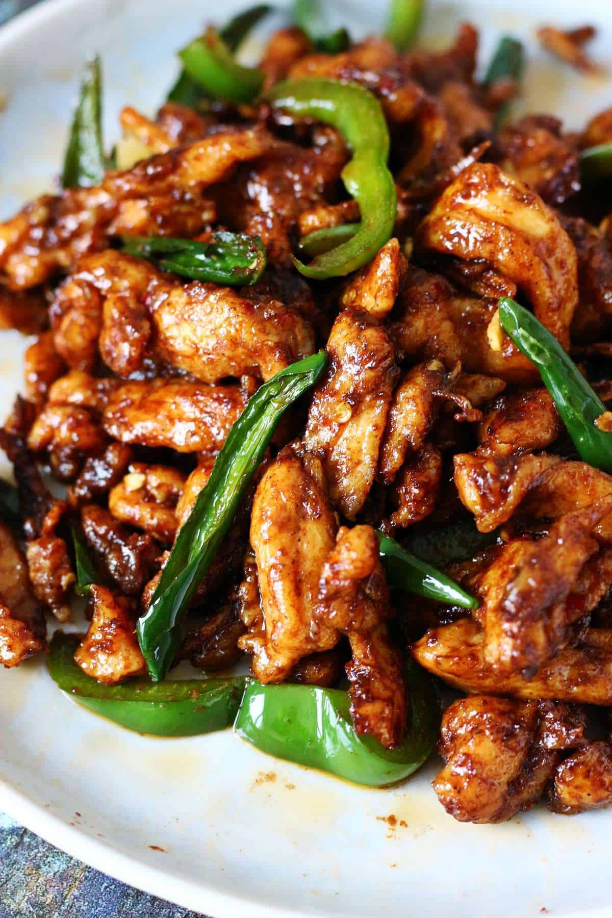 Close-up of Chinese Chicken Chili Dry with saucy chicken pieces and sliced green chilies.