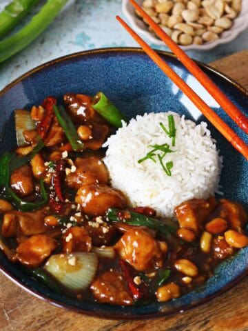 Kung Pao Chicken stir-fry with chicken, peanuts, dried red chilies, and onion in a bold, glossy sauce.