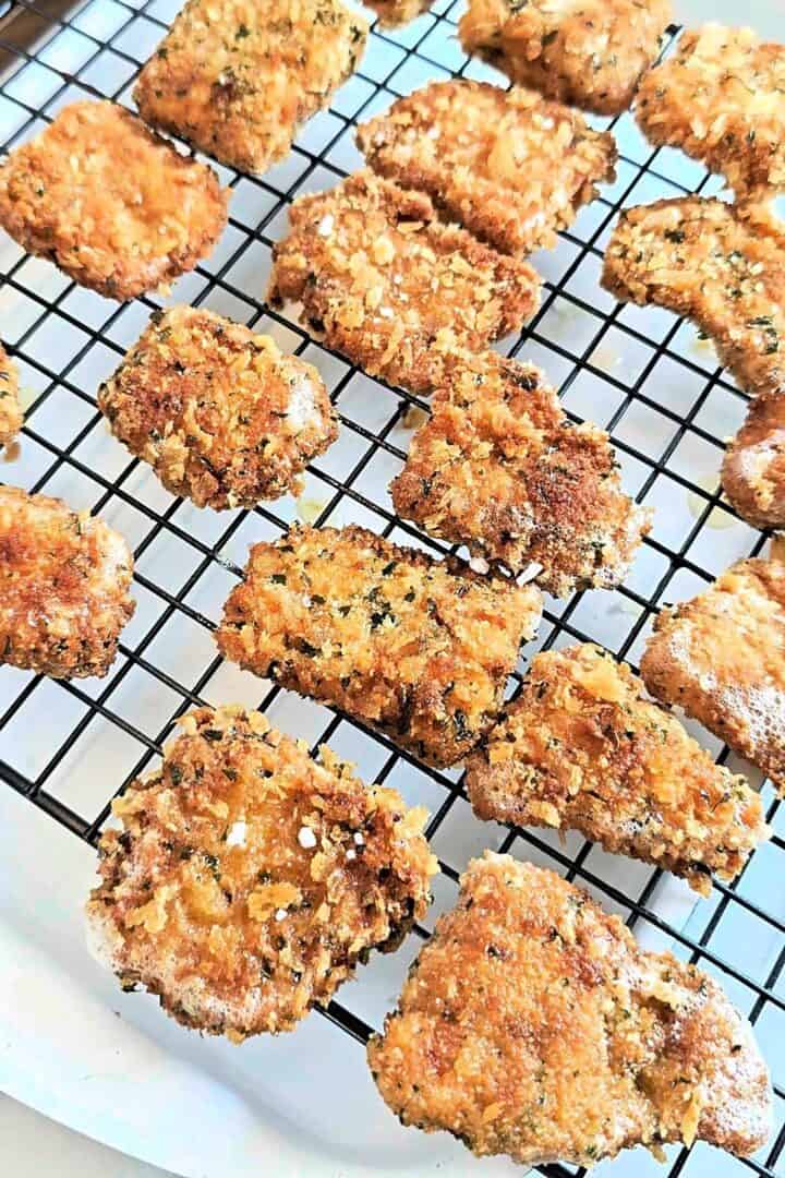 Fried fish nuggets resting on a wire rack.