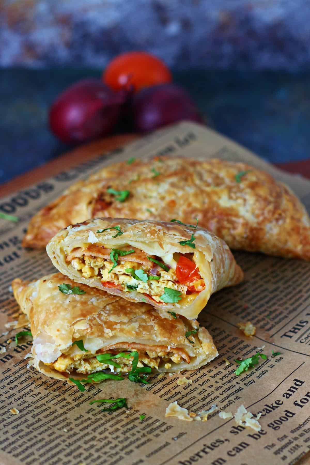 Sliced paratha pockets on parchment paper with another whole pocket in the background.