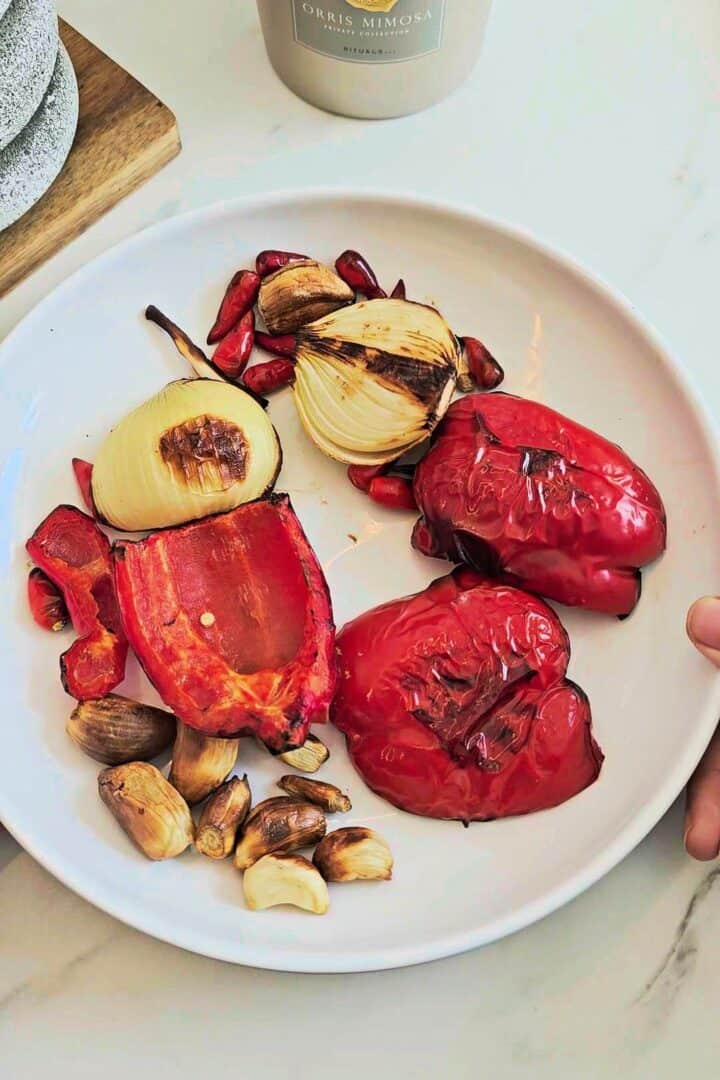 Charred red bell peppers, onion, garlic, and bird’s eye chilies roasted for peri peri sauce.
