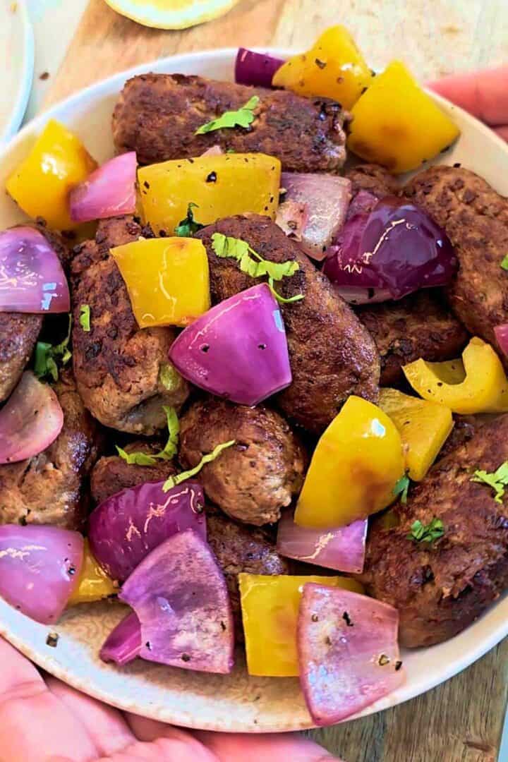 Pakistani gola kababs served with sautéed onions, bell peppers, and fresh cilantro.