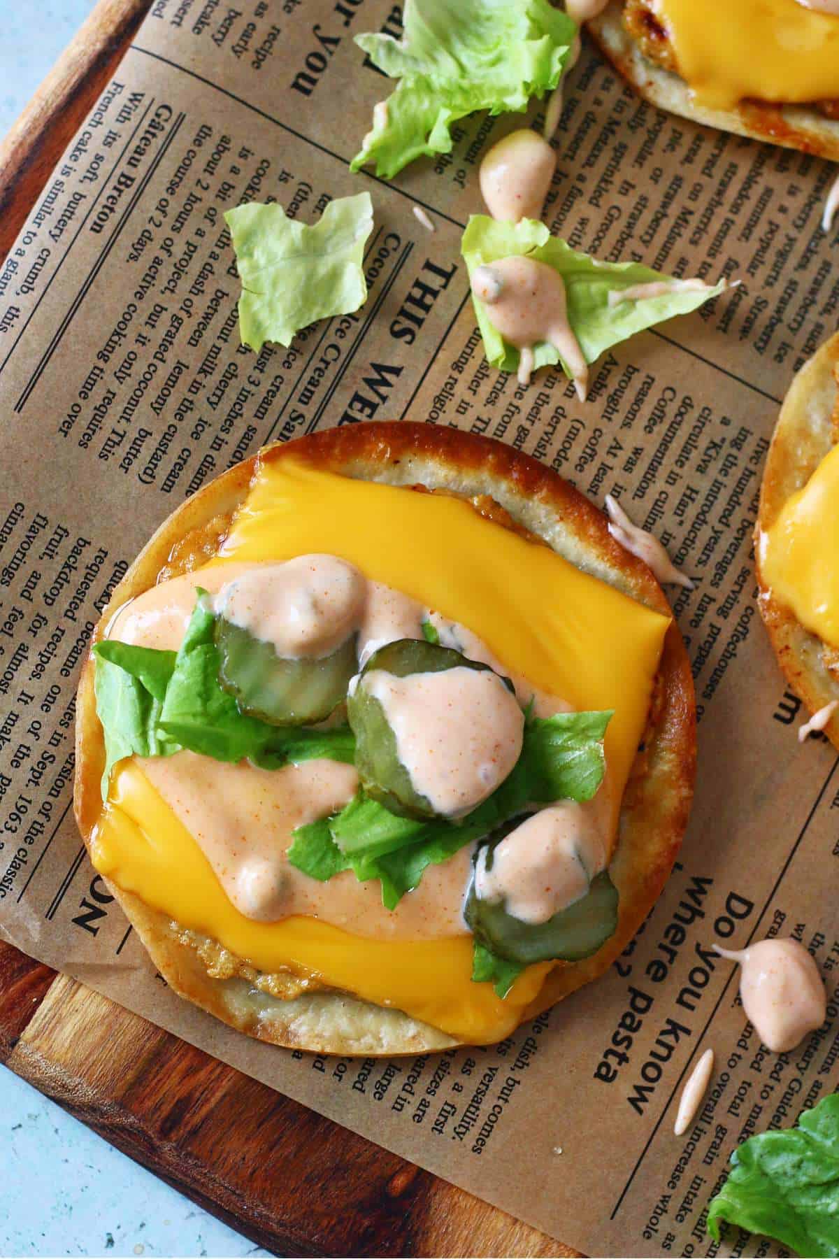Close-up of an open-faced Chicken Big Mac smash taco topped with melted cheese, lettuce, pickles, and creamy sauce.
