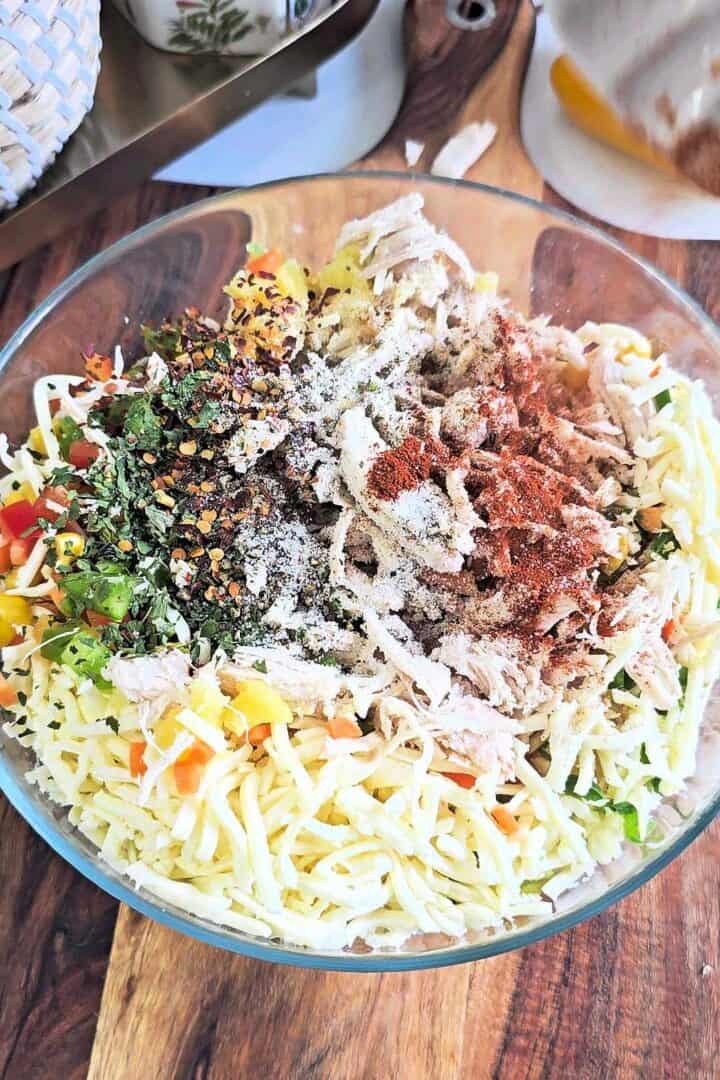 Bowl with chicken, mashed potato, vegetables, cheese, and seasonings for croquettes.