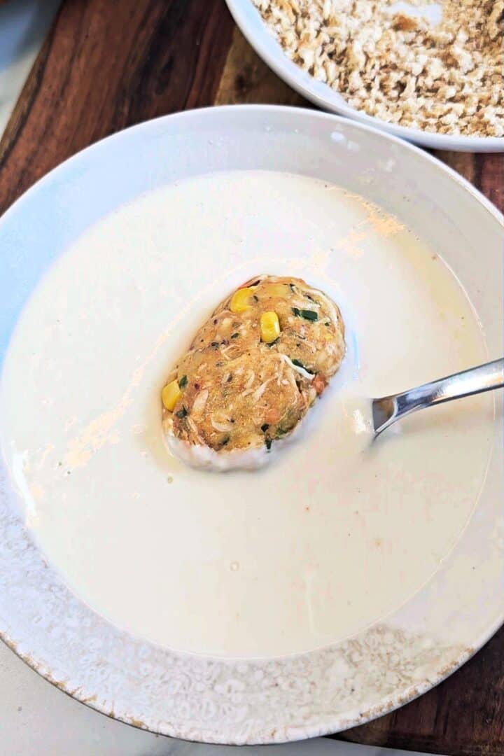 Dipping a chicken croquette into the flour slurry.