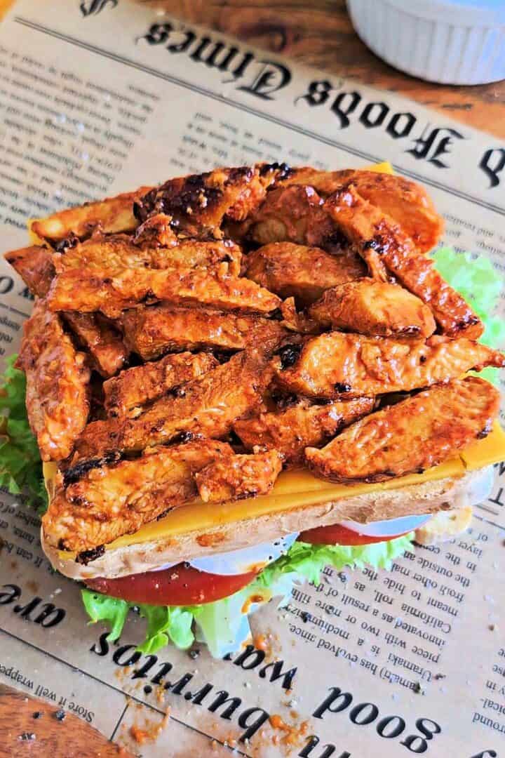 Tandoori chicken and cheddar layered on the middle slice of a club sandwich.