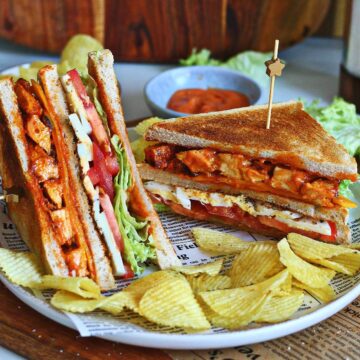 Tandoori chicken club sandwich served with potato chips and homemade tandoori mayo.