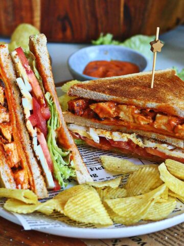 Tandoori chicken club sandwich served with potato chips and homemade tandoori mayo.