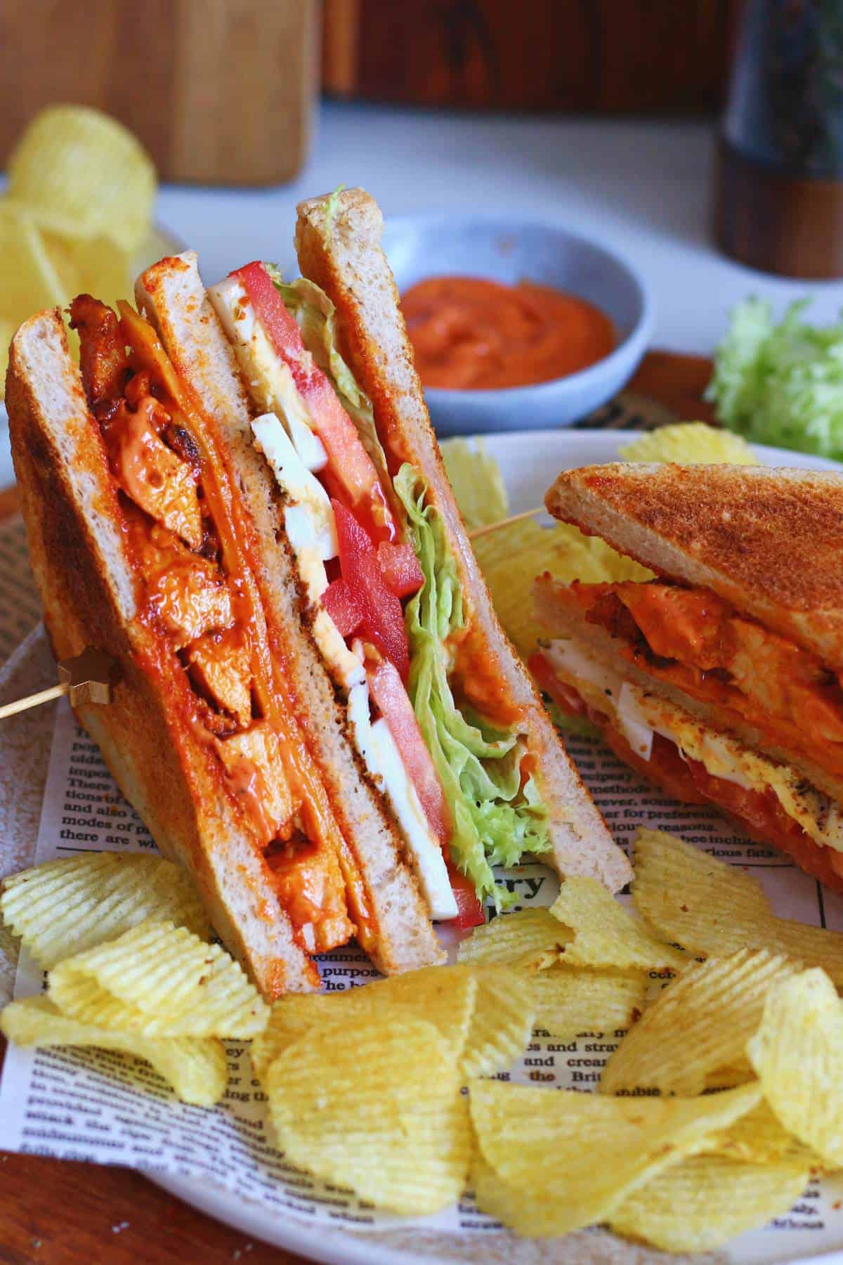 Tandoori chicken club sandwich served with ridged potato chips and homemade tandoori mayo.
